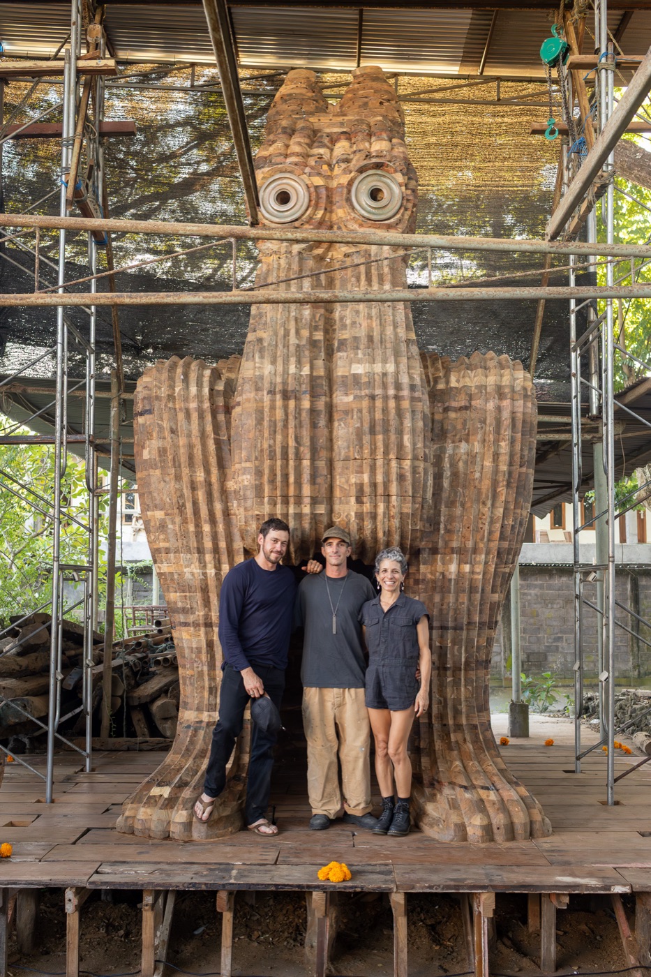 The three-person US team standing at the base of the Behind Closed Eyes sculpture